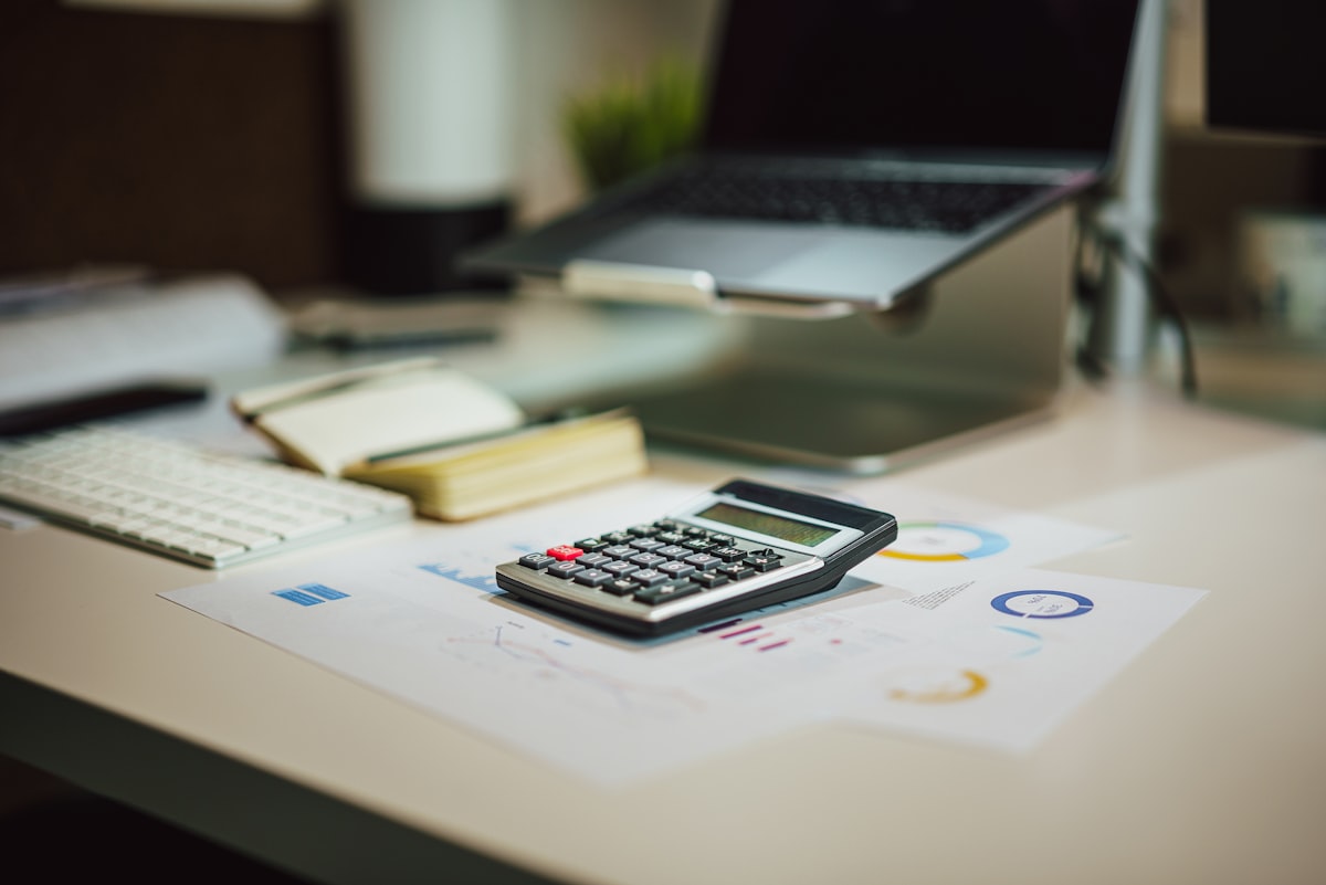 House key with calculator and financial documents on desk for loan-to-value property analysis